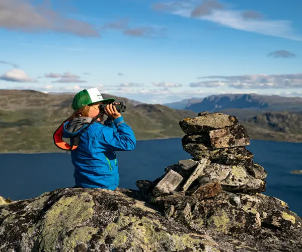 Gutt ser i kikkert på Jotunheimen sine majestetiske fjell