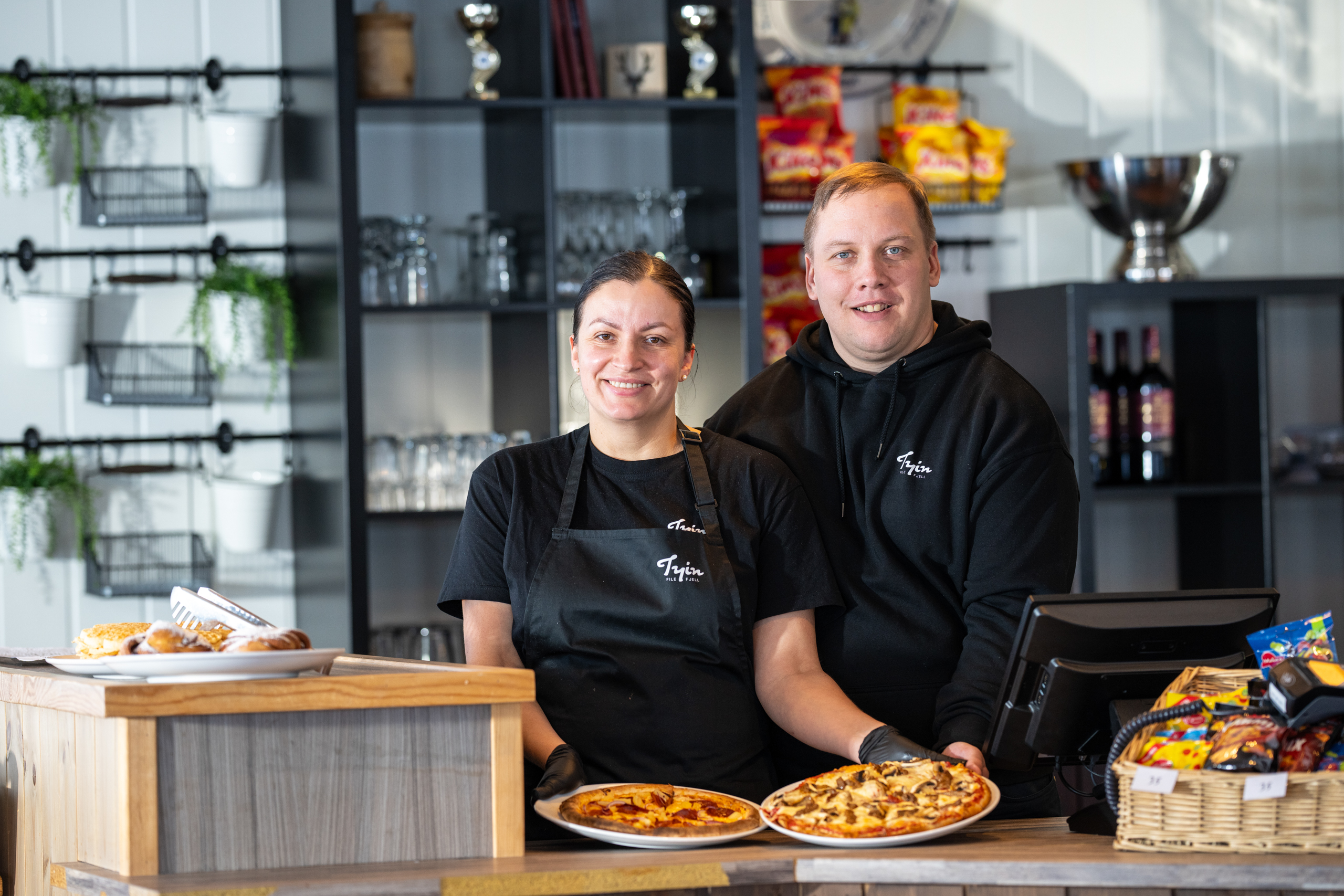 Servitører serverer pizza i Skikafeen i Tyin Filefjell Skisenter